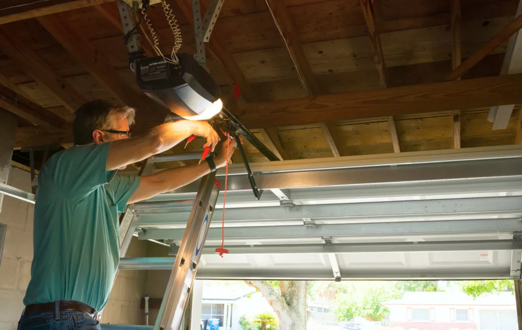 A professional installing a modern garage door opener