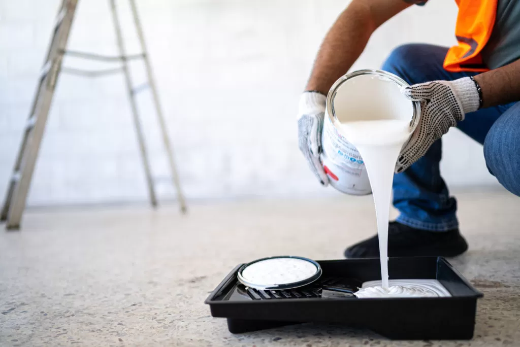 Man pouring paint into tray. Can you paint aluminum garage doors?